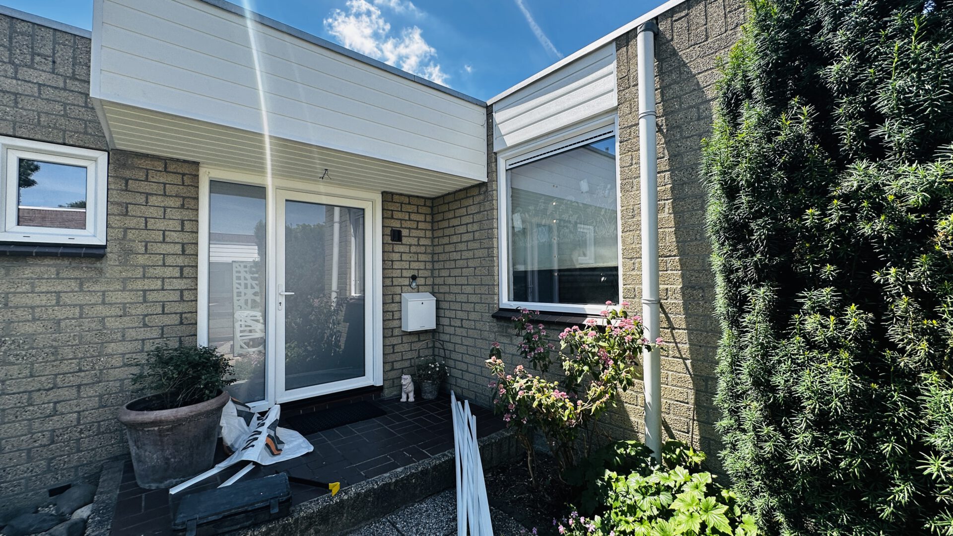 Woningentree met witte kozijnen en Keralit gevelbekleding