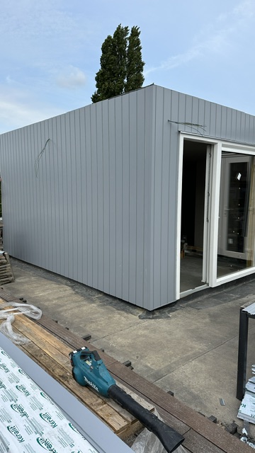 Dakopbouw in Amsterdam-Osdorp met lichte gevelbekleding en witte kozijnen