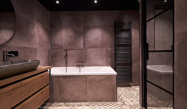 Ligbad met donker tegelwerk en sfeerverlichting – Liebkes, Trerom B.V.