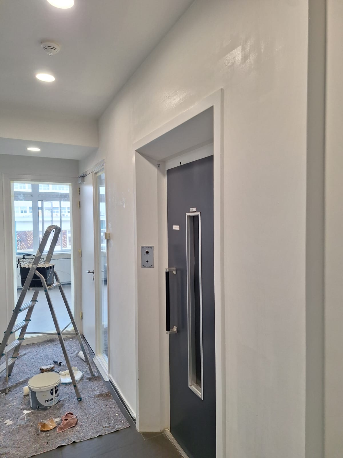 Witte wand en deuromlijsting bij de lift in kantoorpand Schinkelhaven, Amsterdam